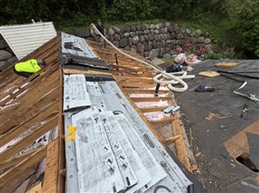 Residential roof tear-off exposing framing and decking in Burnsville MN